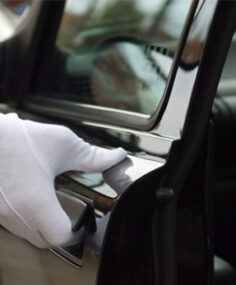 A gloved hand opening a limo door